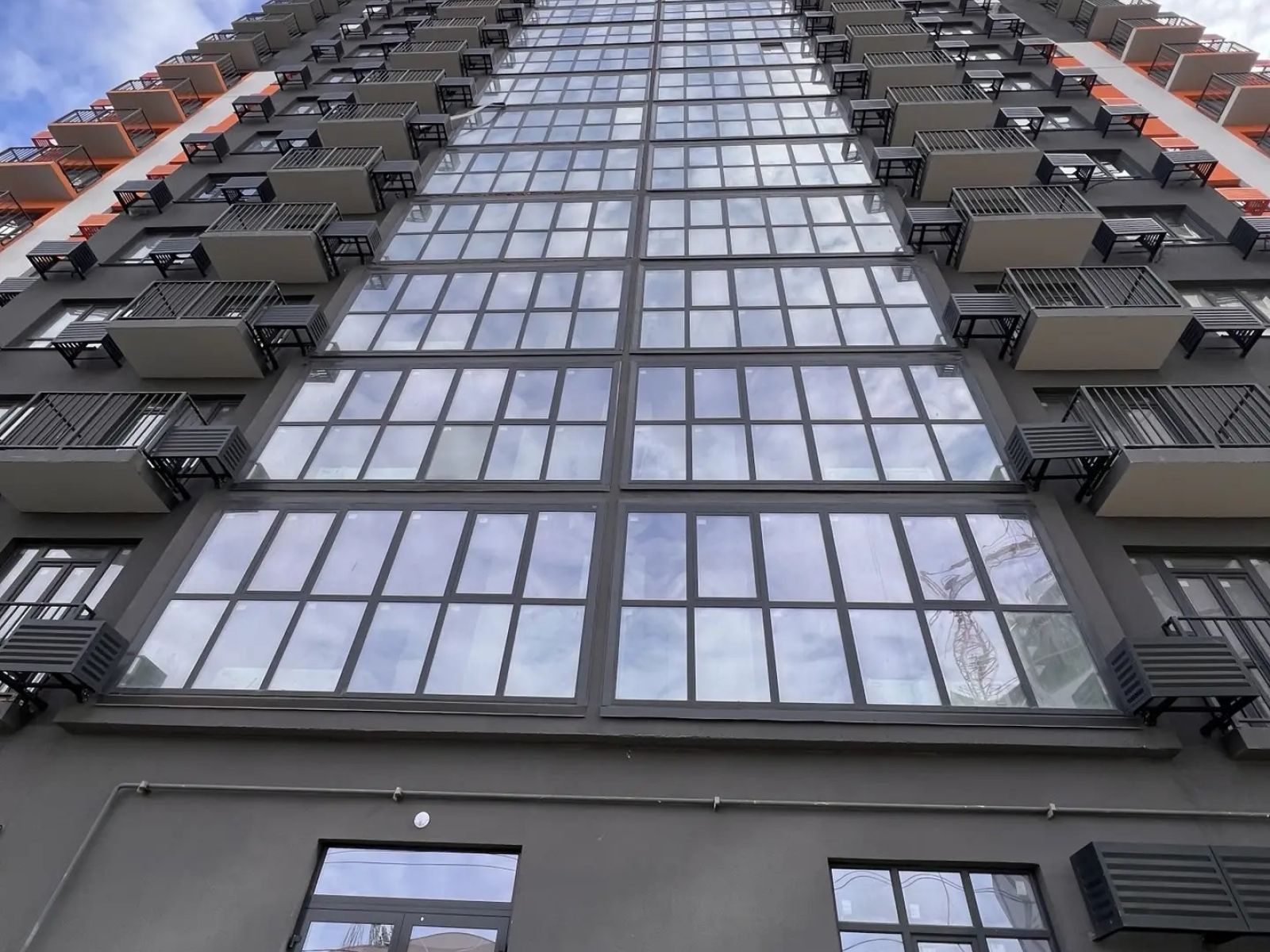 Панорамное остекление и фасад многоэтажного дома с рядами окон